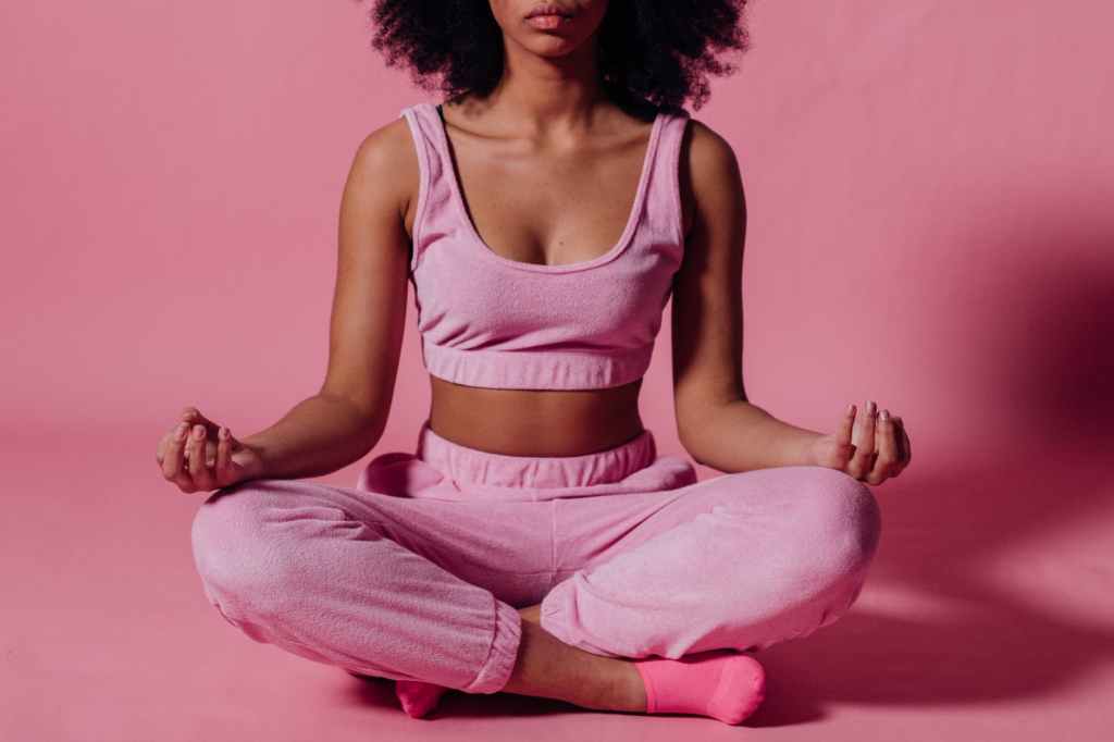 woman in pink crop top and jogging pants practicing yoga