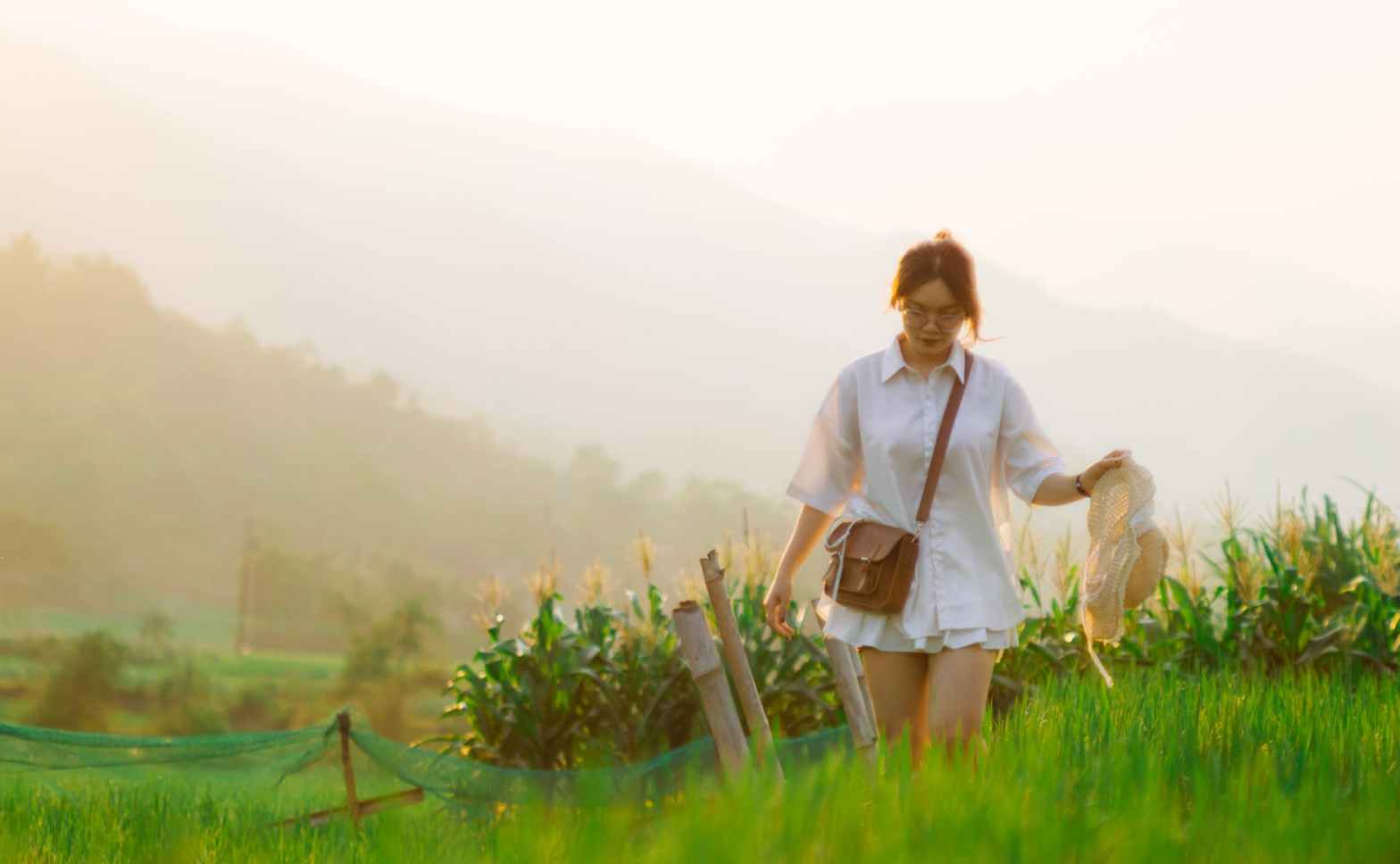 woman walking through grass field