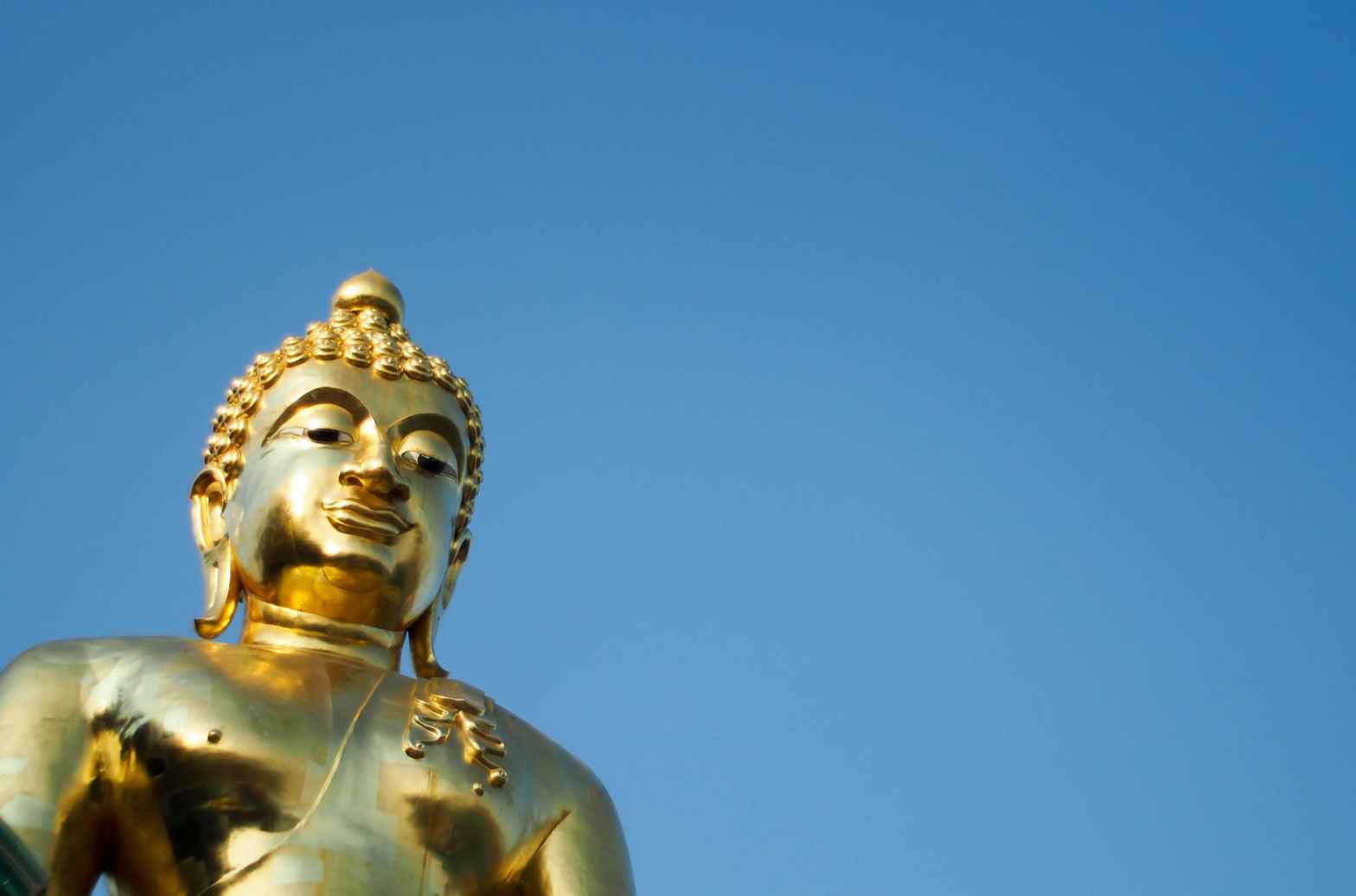 golden statue of a buddha in low angle shot